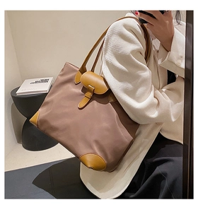 Brown nylon tote bag with leather handles shown in a casual mirror selfie context