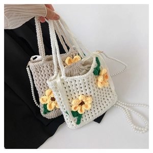 Detail of handcrafted sunflower crochet mini bag with pearl strap and drawstring pouch