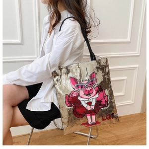 Close-up of golden sequins texture and cartoon pig embroidery on the large tote bag