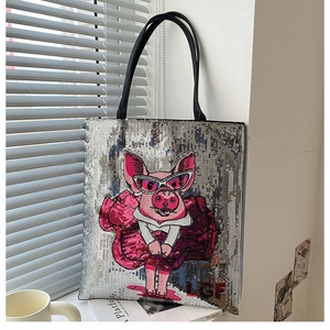 Detail of silver sequin tote bag featuring cartoon pink pig and black shoulder straps