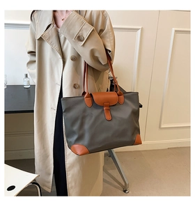 Close-up of a French-style oxford fabric tote bag with contrast leather trim on a model