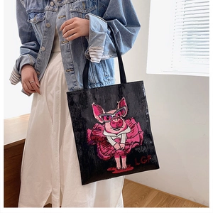 Close-up of a large black tote bag featuring a pink sequined cartoon pig and LGFI logo