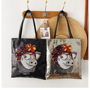 Detail of silver and black sequin tote bags with cute cartoon pig design on wooden hangers
