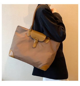 Detailed shoulder view of a large oxford cloth tote bag with caramel leather accents