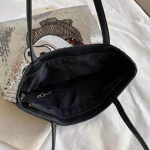 Detail view of large black tote bag featuring sequin cartoon design and inner zipper pocket