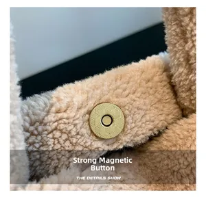 Détail du fermoir magnétique doré sur un sac à main en peluche beige de type seau