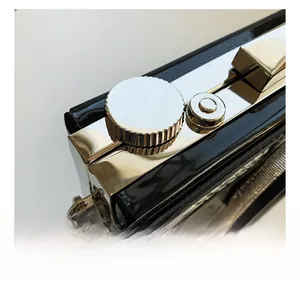 Detail of vintage camera shaped bag with glossy black finish and metal hardware parts