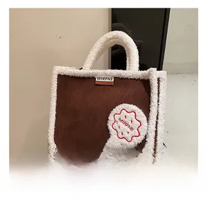 Detailansicht der braunen Wildledertasche mit weißem Teddyfell-Besatz und MIRFNE-Label
