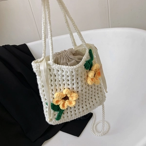 Handmade crochet bucket bag with yellow flowers, drawstring pouch, and pearl chain strap