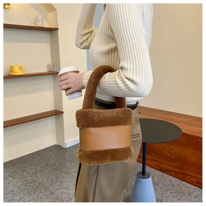 Détail du sac seau en peluche marron et cuir avec finitions élégantes d'automne