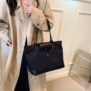 Chic black nylon tote bag with leather straps and flap, elegant French commute style