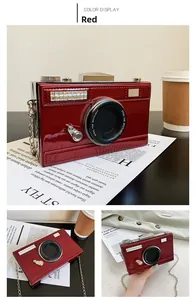Detailed view of red patent leather camera-shaped bag with silver chain and slogan