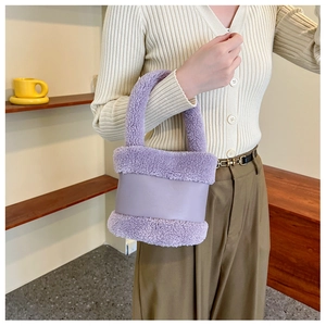 Détail d'un sac à main en peluche lilas et cuir tenu par un mannequin en intérieur