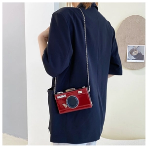 Detailed back view of model wearing a vintage red camera-shaped chain crossbody bag