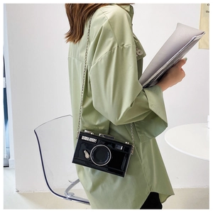 Detail of creative vintage camera crossbody bag with silver chain and glossy finish