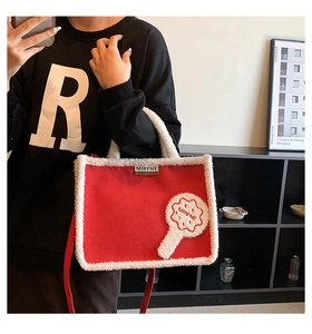 Detail of red suede tote with white faux fur trim shown on model for size and style
