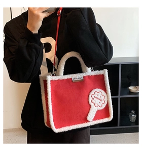 Detailansicht der roten Plüschhandtasche mit weißem Lammfellbesatz und metallischem Markenlogo