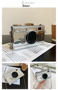 Detail of silver camera-shaped crossbody bag with rhinestones and chain strap