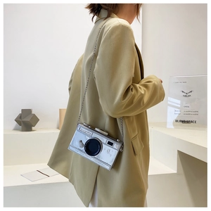 Close-up of a creative silver camera-shaped crossbody bag with a metallic chain strap
