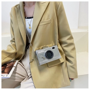 Detail of creative silver camera shaped crossbody bag with metallic chain and lens decor