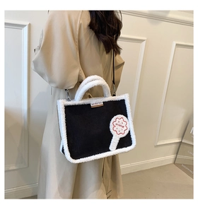 Detail of plush black tote bag with white faux fur trim and MIRFNE cookie embroidery patch