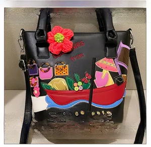 Detail of black leather bucket bag with ethnic Thailand embroidery and souvenir patches