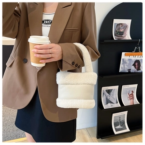 Détail de la matière en peluche blanche et cuir sur le sac seau élégant pour l'hiver