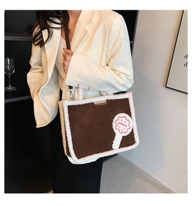 Detail of chocolate brown suede tote bag with white faux fur trim and flower appliqué