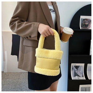Gros plan d'un sac seau en peluche jaune vif avec patchwork de polaire et cuir