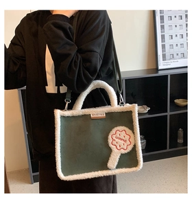 Detail of green suede tote bag with white faux fur trim and adjustable shoulder strap