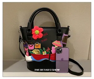 Detail view of black bucket bag with handmade crochet flowers and decorative appliques