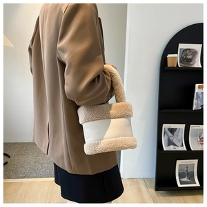 Détail du sac seau élégant en cuir blanc avec garniture en peluche et poignées en fourrure