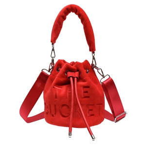 Fashionable red plush bucket bag with embossed The Bucket lettering and wide strap