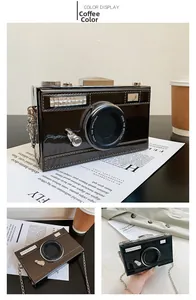 Detail of camera-shaped chain bag showing vintage lens design and glossy finish