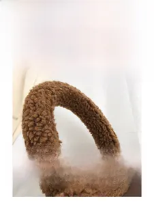 Close-up of brown teddy fleece handbag handle with soft plush texture and curved design