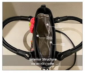 Internal view of black bucket bag featuring main pocket, phone pouch and zipper pocket