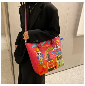 Detailansicht der pinkfarbenen mexikanischen Tragetasche an einem Model im schwarzen Blazer.