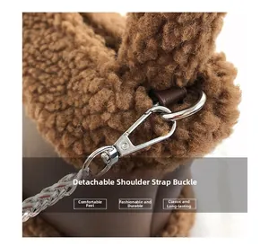 Detail of silver metal detachable strap buckle on a brown plush lambskin bucket bag