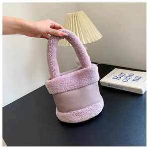 Détail d'un sac seau en peluche violette avec fausse fourrure douce et cuir lisse