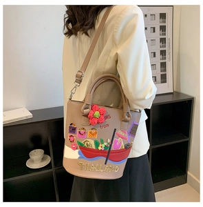 Detailed view of beige bucket bag with Thailand embroidery and colorful beadwork