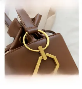 Detail of premium brown leather texture with vintage gold ring hardware on bucket bag