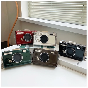 Close-up of vintage camera-shaped clutch bags in various colors with metal chains