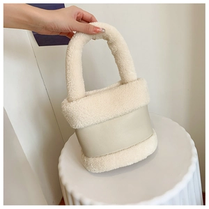Détail du sac seau en polaire et cuir avec texture de poignée crème douce et élégante