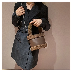 Detail of brown faux fur patchwork bucket bag with silver chain strap on a model