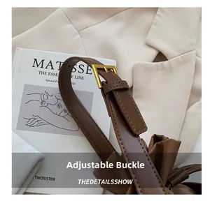 Close-up of the adjustable golden buckle and premium brown leather strap on the bucket bag
