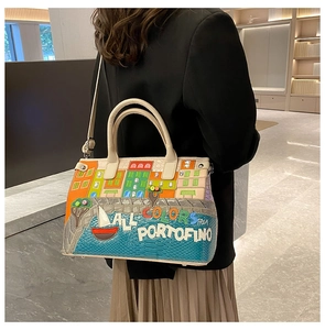 Detail of Portofino scenery embroidery and leather texture on a chic handbag