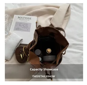 Overhead view showing large storage capacity of brown drawstring bucket bag with cosmetics
