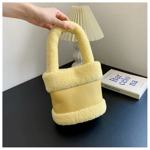 Vue détaillée du sac seau en similicuir jaune avec bordure en laine d'agneau pelucheuse