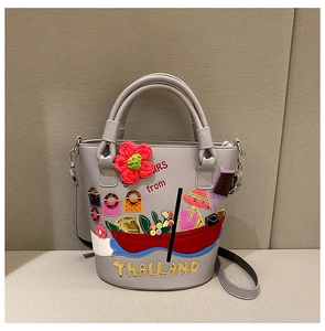 Close-up of ethnic bucket bag with colorful Thailand embroidery and 3D floral details