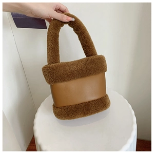 Détail du sac à main seau cylindrique en peluche et patchwork de cuir marron